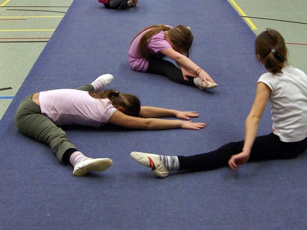 Mädchen bei Dehnübungen auf der Bodenmatte